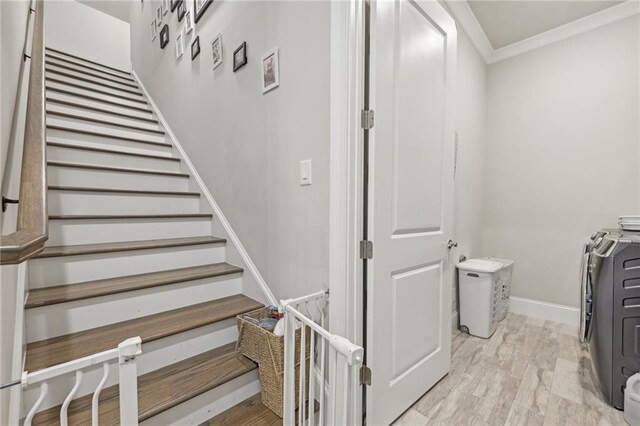 staircase with ornamental molding, hardwood / wood-style floors, and washer and dryer