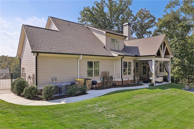 rear view of property featuring central AC, a patio area, and a yard