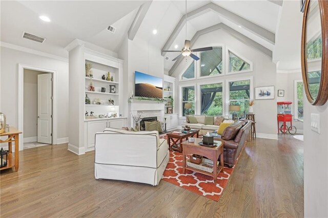 living room with beam ceiling, hardwood / wood-style floors, ceiling fan, and high vaulted ceiling