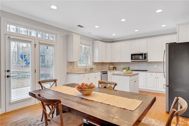 kitchen featuring sink, a center island, white cabinets, and appliances with stainless steel finishes