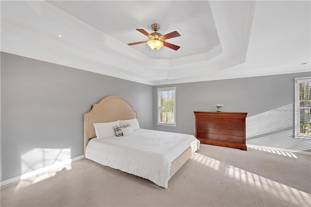 bedroom with a tray ceiling, ornamental molding, ceiling fan, and carpet flooring