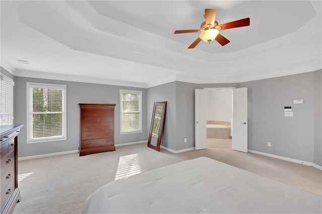 bedroom featuring a raised ceiling, crown molding, connected bathroom, and ceiling fan