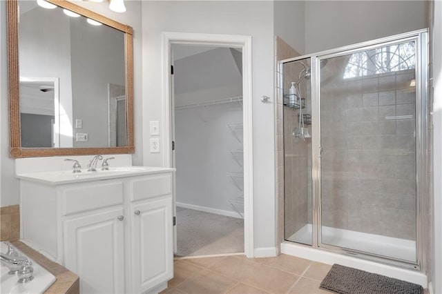 bathroom featuring tile patterned flooring, vanity, and a shower with door