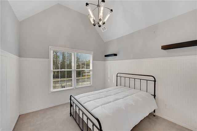 carpeted bedroom featuring high vaulted ceiling and a chandelier