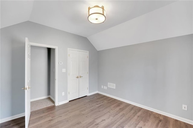 additional living space with vaulted ceiling and hardwood / wood-style floors