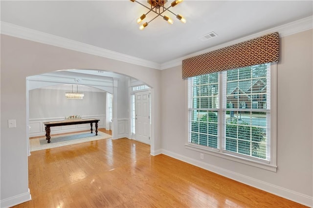 foyer featuring ornamental molding, wood-type flooring, and a notable chandelier