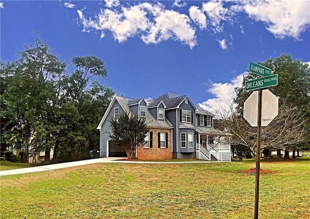 view of front of house featuring a garage, brick siding, driveway, and a front lawn