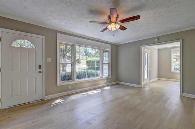 foyer with ceiling fan, light hardwood / wood-style flooring, and a textured ceiling