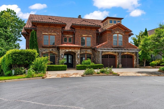 2742 High Vista Pt, Gainesville, GA 30501 - mediterranean / spanish-style home with a tile roof, driveway, an attached garage, stone siding, and a chimney