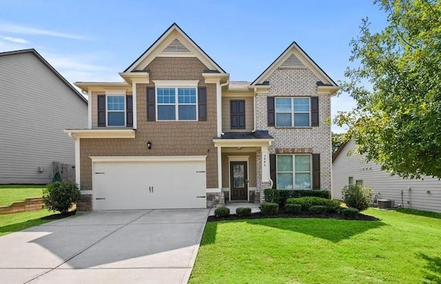 craftsman-style home with central air condition unit, a garage, and a front yard