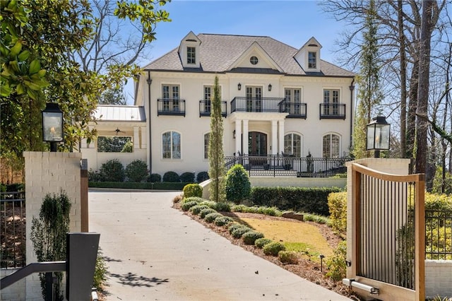 french provincial home with fence and a balcony