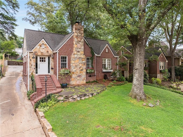 311 Glendale Ave, Decatur, GA 30030 - tudor house featuring a front yard, stone siding, a chimney, and driveway