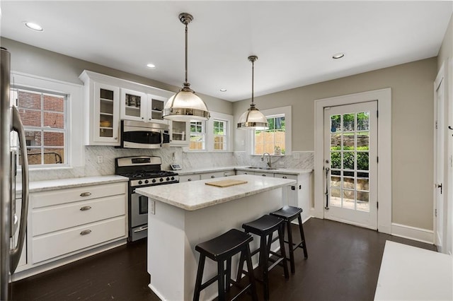 311 Glendale Ave, Decatur, GA 30030 - kitchen featuring stainless steel appliances, tasteful backsplash, white cabinets, a kitchen island, and glass insert cabinets