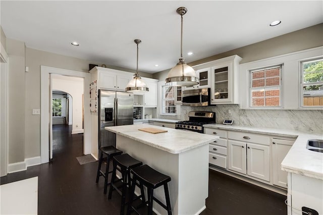 311 Glendale Ave, Decatur, GA 30030 - kitchen featuring appliances with stainless steel finishes, a kitchen bar, a center island, white cabinetry, and tasteful backsplash