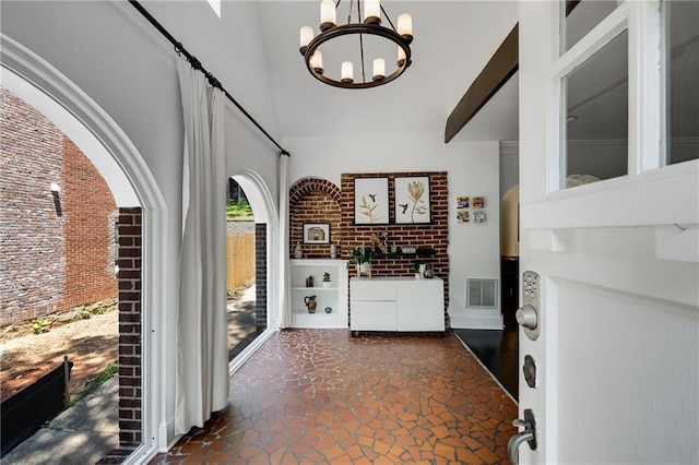 311 Glendale Ave, Decatur, GA 30030 - entrance foyer with a chandelier, a high ceiling, brick wall, and stone finish flooring