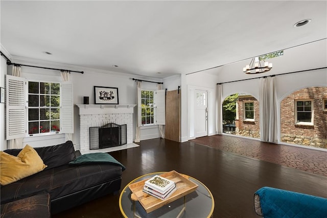 311 Glendale Ave, Decatur, GA 30030 - living room featuring a chandelier, wood finished floors, a brick fireplace, and crown molding