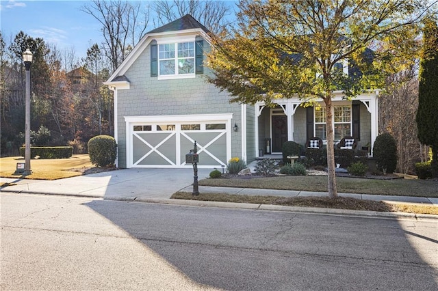 traditional-style home with a porch, an attached garage, and driveway