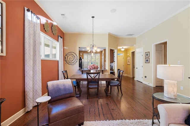 dining space with ornamental molding, a chandelier, baseboards, and dark wood-type flooring