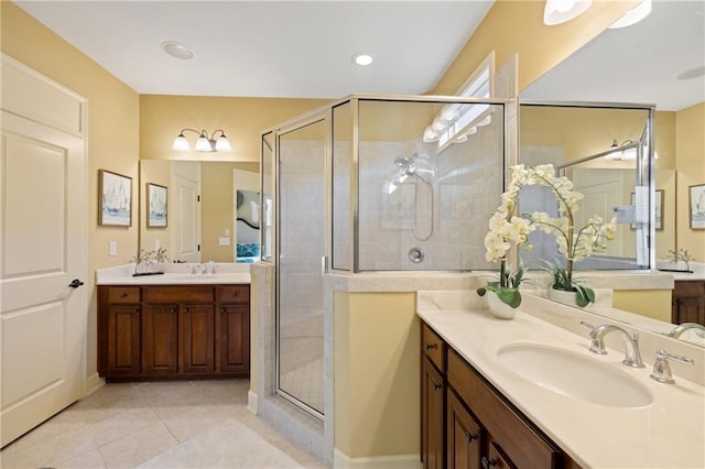 full bath featuring a shower stall, tile patterned floors, two vanities, and a sink