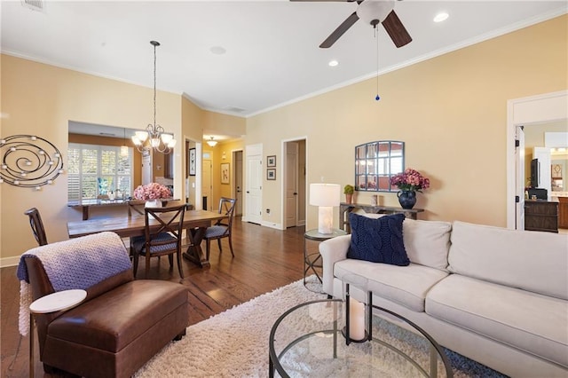 living room with ornamental molding, ceiling fan with notable chandelier, baseboards, and wood finished floors