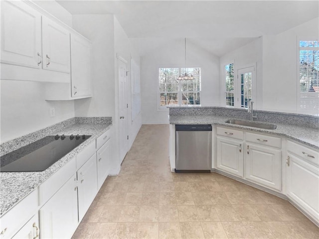 kitchen featuring light stone counters, sink, stainless steel dishwasher, and white cabinets