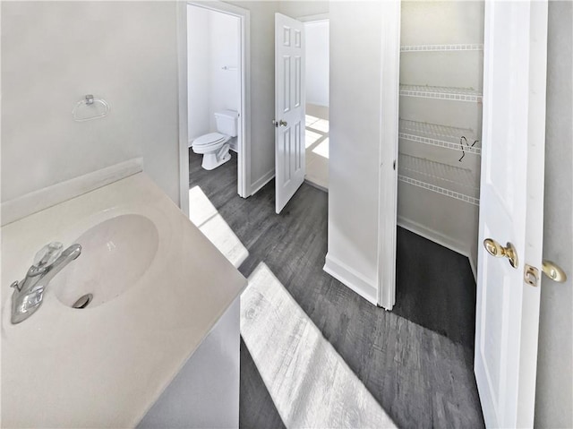 bathroom with hardwood / wood-style floors, sink, and toilet