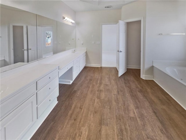 3905 Colonial Trl SW, Lilburn, GA 30047 - bathroom with double vanity, wood finished floors, a garden tub, and baseboards