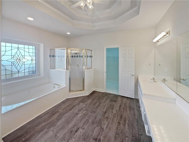 bathroom with hardwood / wood-style floors, independent shower and bath, vanity, a tray ceiling, and crown molding