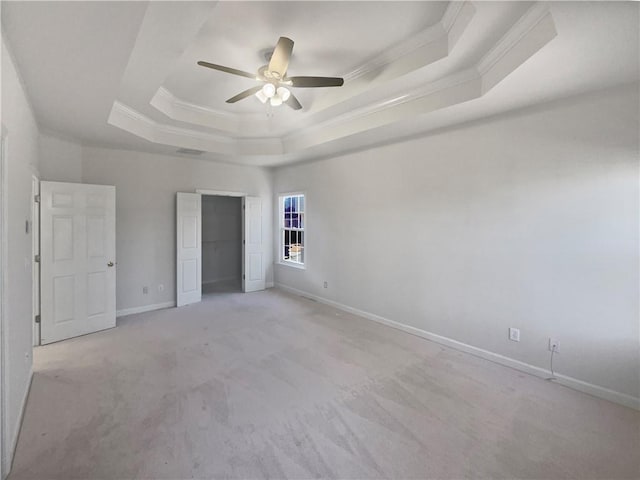 unfurnished bedroom with light carpet, ornamental molding, a raised ceiling, and ceiling fan