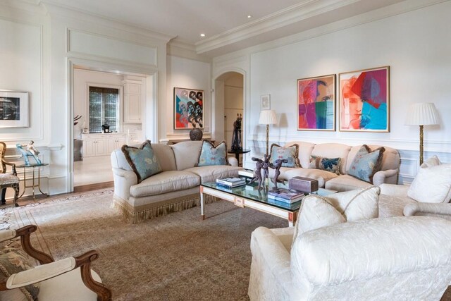 living room with arched walkways, crown molding, and recessed lighting