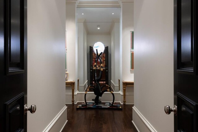 exercise area with dark wood-style floors, baseboards, and crown molding