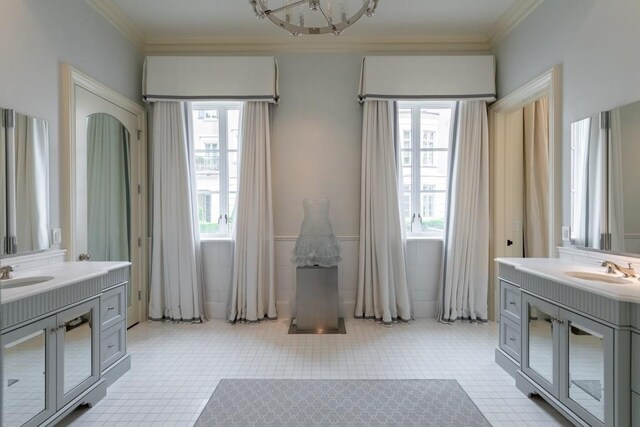 bathroom with crown molding, two vanities, and tile patterned floors