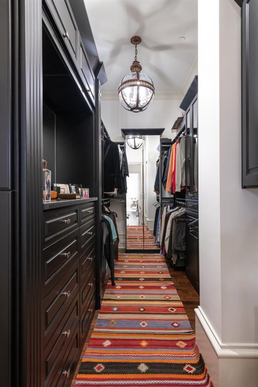 walk in closet with dark wood-style flooring