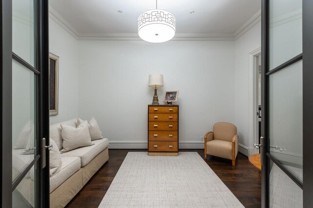 sitting room featuring dark wood finished floors, baseboard heating, and ornamental molding