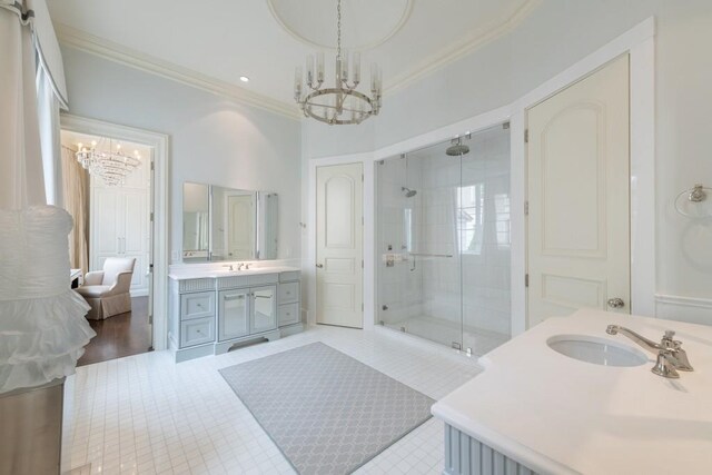 bathroom featuring two vanities, a chandelier, and ornamental molding