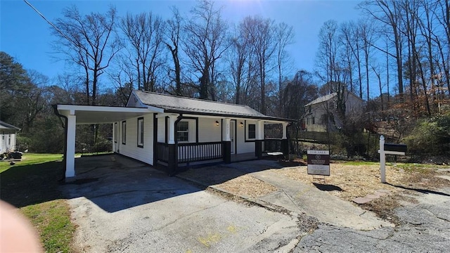 view of front of home featuring a carport, covered porch, and driveway