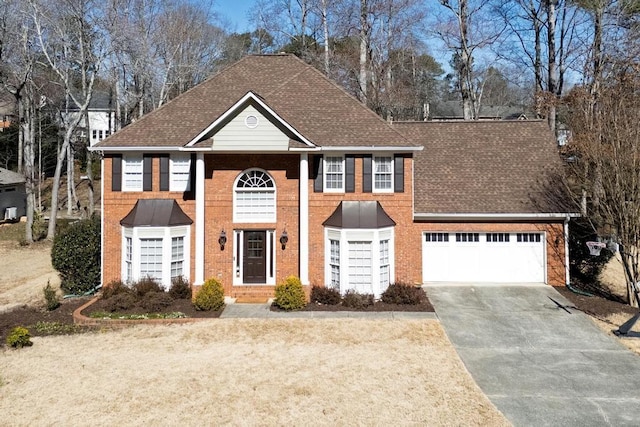 view of front of home featuring driveway, an attached garage, a shingled roof, and brick siding