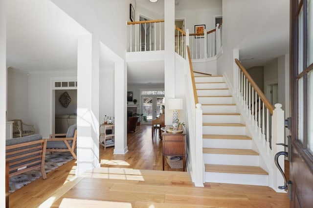 foyer featuring a high ceiling, stairway, wood finished floors, and visible vents