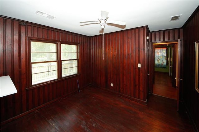 empty room with ceiling fan and dark wood-type flooring