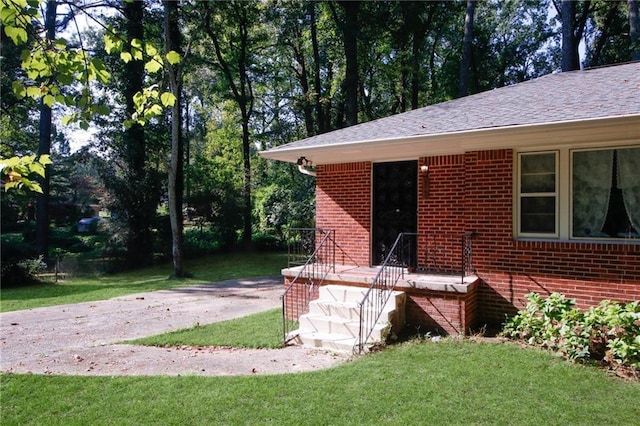 doorway to property featuring a lawn