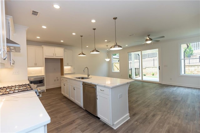 kitchen with sink, white cabinetry, light stone counters, an island with sink, and stainless steel appliances