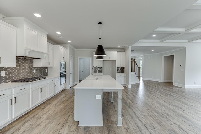 kitchen with appliances with stainless steel finishes, tasteful backsplash, baseboards, white cabinetry, and a sink