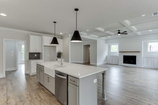 kitchen featuring a sink, dishwasher, light countertops, a ceiling fan, and light wood-style floors