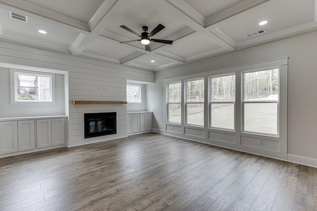 unfurnished living room featuring healthy amount of natural light, coffered ceiling, ceiling fan, wood finished floors, and a fireplace