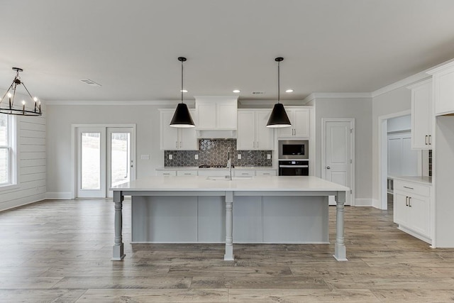 kitchen with oven, ornamental molding, baseboards, light countertops, and recessed lighting