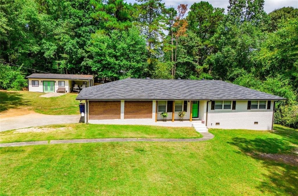 view of front of property with crawl space, driveway, a front lawn, and brick siding