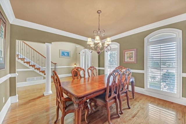 2740 Heritage Bend Ct SW, Grayson, GA 30017 - dining room featuring a chandelier, arched walkways, light wood-style flooring, baseboards, and ornamental molding