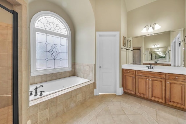 2740 Heritage Bend Ct SW, Grayson, GA 30017 - bathroom featuring tile patterned flooring, lofted ceiling, a garden tub, and vanity