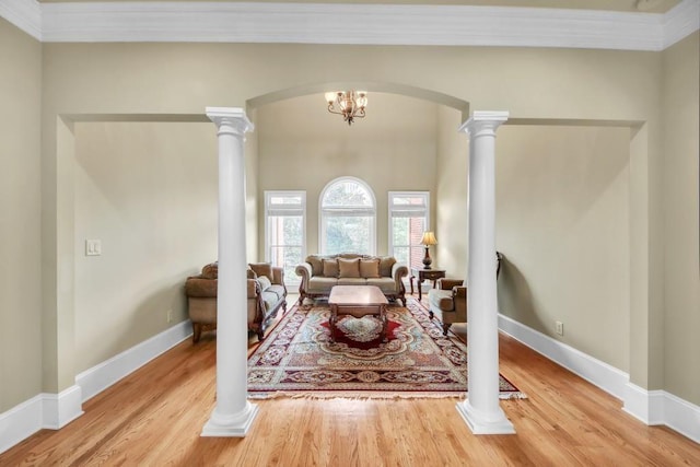2740 Heritage Bend Ct SW, Grayson, GA 30017 - living room with arched walkways, wood finished floors, decorative columns, and crown molding