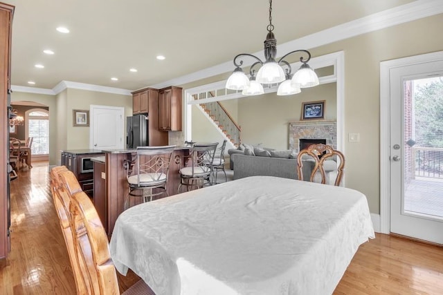 2740 Heritage Bend Ct SW, Grayson, GA 30017 - dining room with a chandelier, ornamental molding, light wood-type flooring, arched walkways, and recessed lighting